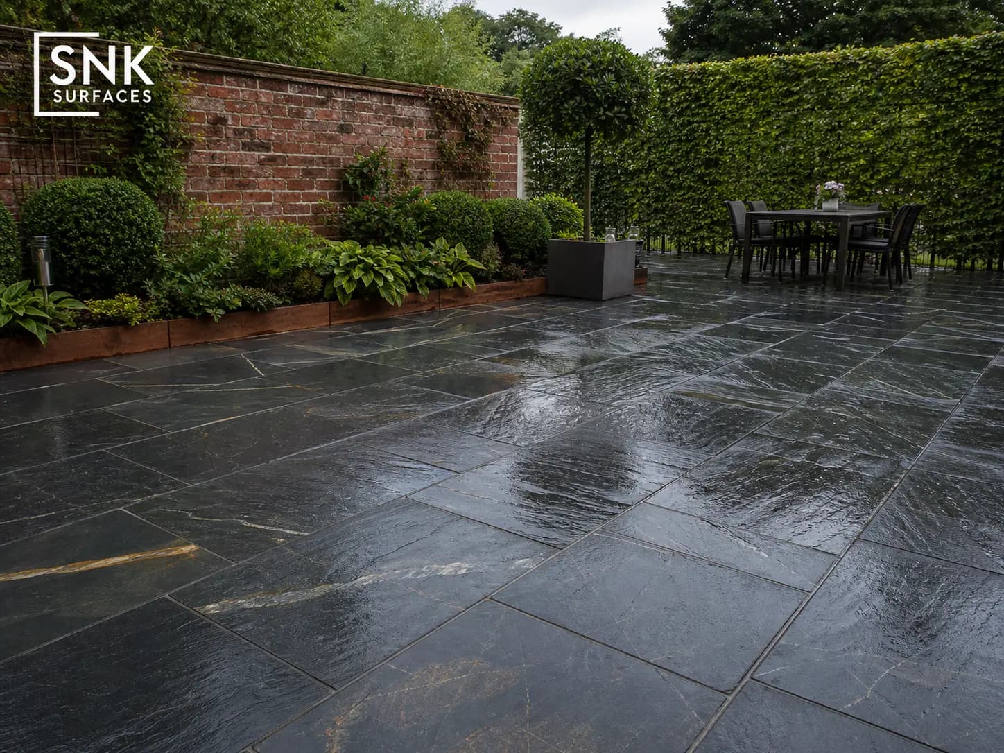 UK garden patio laid with Sagar Black Sandstone showing deep charcoal tones and natural riven texture