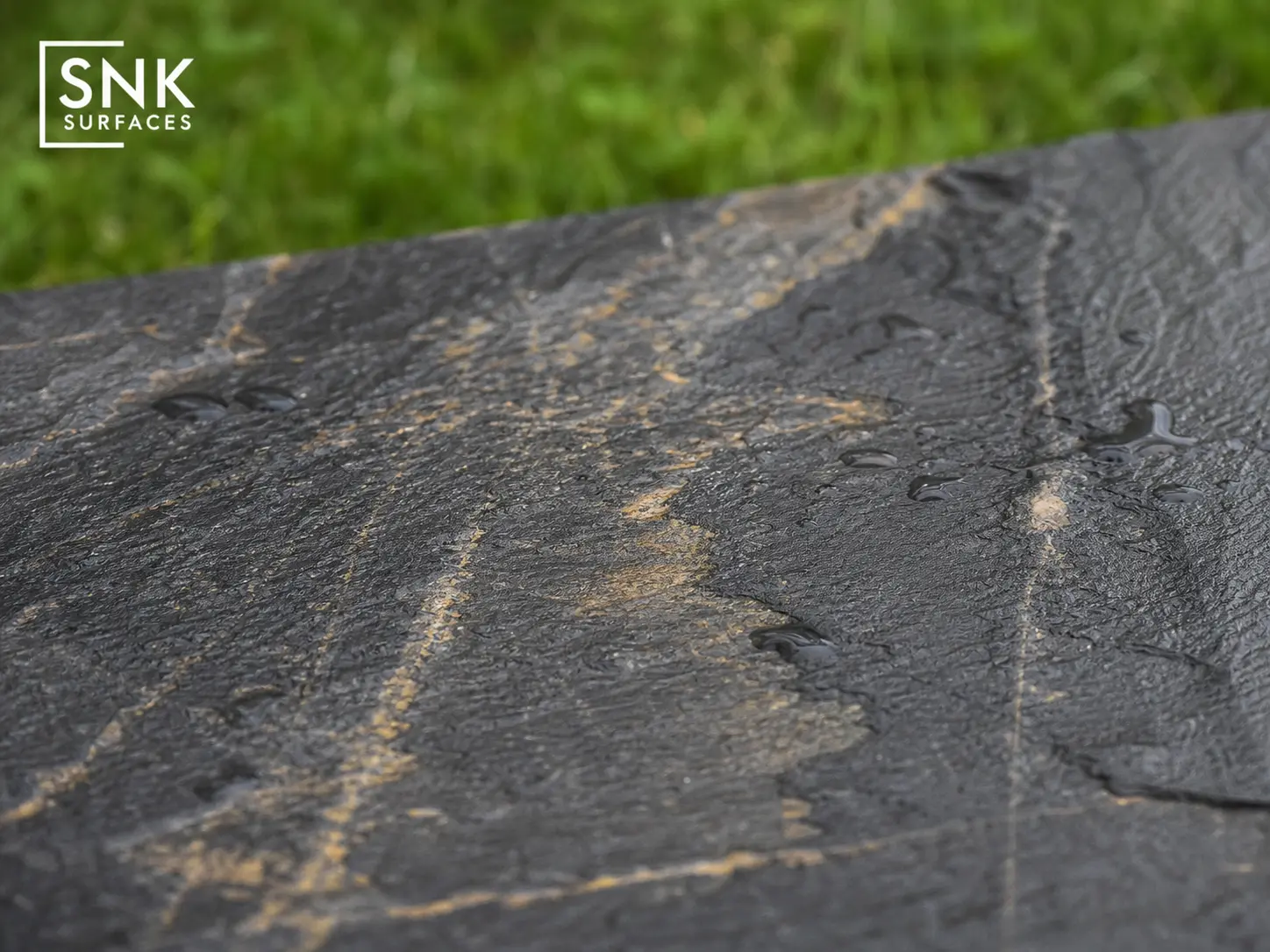 Close-up of Sagar Black Sandstone surface showing natural riven texture with charcoal and gold mineral veining