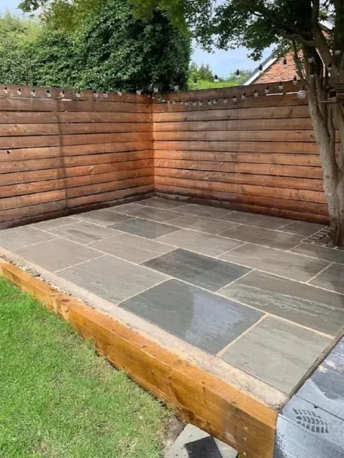 Kandla Grey sandstone patio with timber fencing and sleeper edge