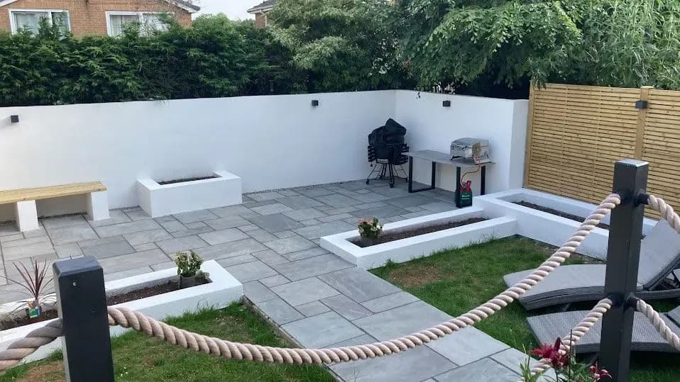 Kandla Grey sandstone patio with white rendered walls and planters