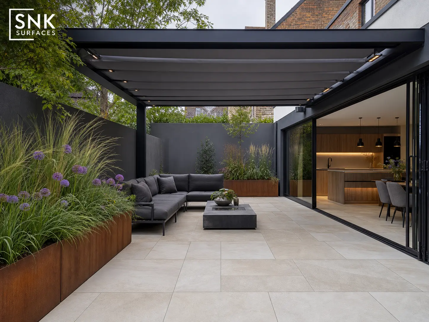 Contemporary UK garden with sawn fossil mint sandstone paving, black aluminium pergola, and Corten steel planters